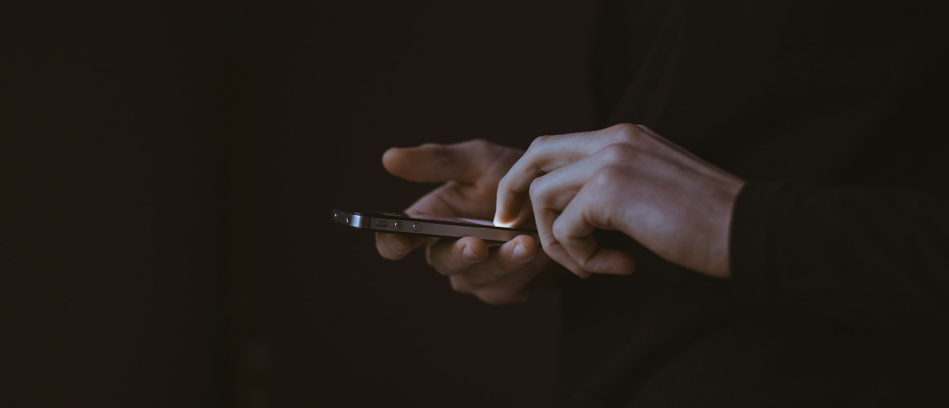 silhouette photo of person holding smartphone